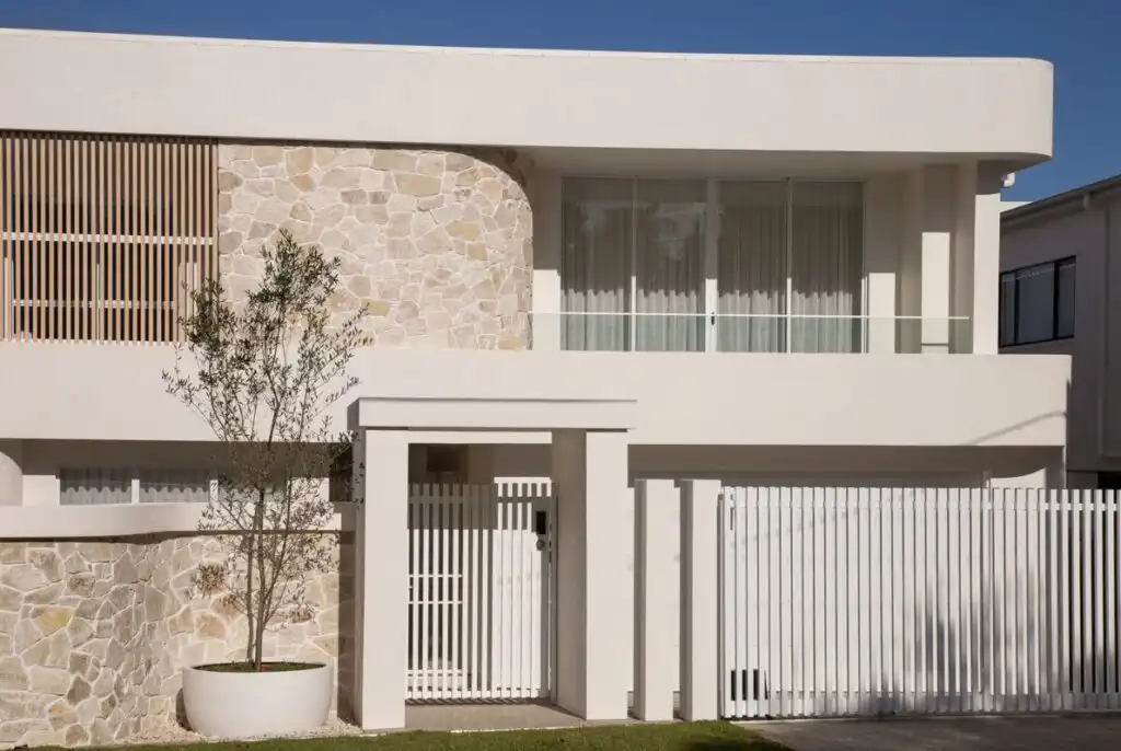 Nimbin loose random wall cladding used across a curved upper facade and front boundary wall of a contemporary home