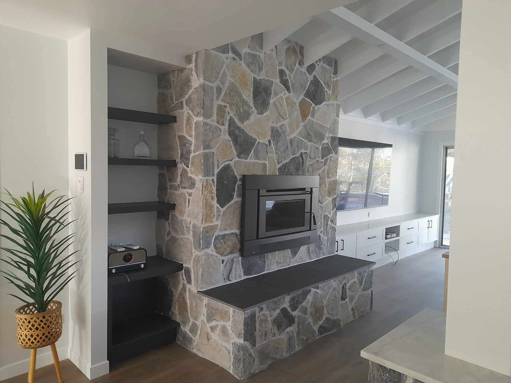 Blue Carbon loose random wall cladding featuring layered blue-grey quartz stone with rustic brown undertones, natural stone veneer and freeform stacked stone wall cladding.
