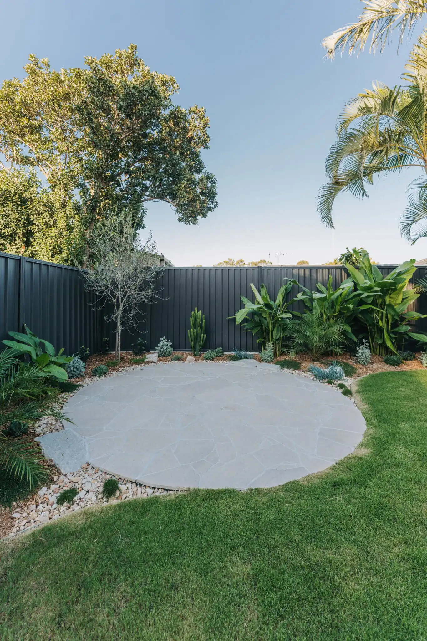 Sinai Pearl limestone crazy pave patio surrounded by landscaped gardens and feature planting