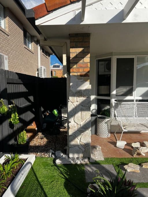Street view of the transformed facade featuring Nimbin Quartz wall cladding. The updated exterior design pairs stone with low-maintenance landscaping for a standout look.