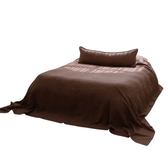 “Eadie Linen Bedcover in Clay draped over a bed, premium 100% linen bedding in warm earthy brown tone.”