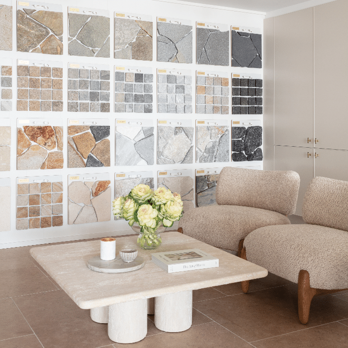 Brisbane showroom interior with a wall display of natural stone tiles and crazy pave samples, representing Stone Design & Co’s stone selection and design services.