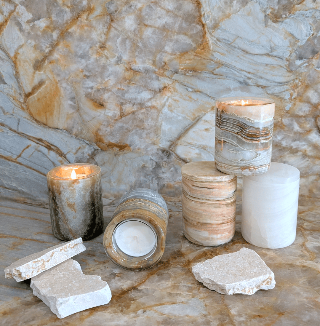 Refillable natural stone candle holders in onyx and marble, styled on a stone surface in an editorial setting