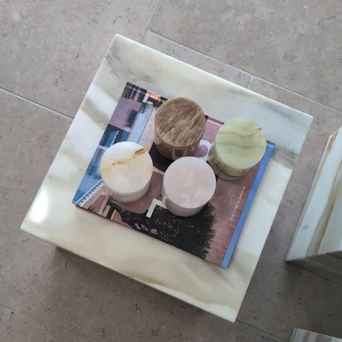 Stone Design & Co refillable natural stone candle vessels displayed on a stone plinth, available with interchangeable candle fragrance refills.