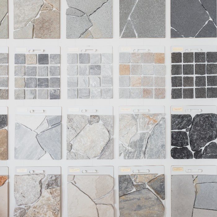 A curated selection of natural stone samples showcasing the texture and tone variations found in limestone, travertine, bluestone and sandstone.
